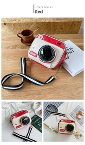 Detail of red vintage camera-shaped crossbody bag with decorative fashion stickers