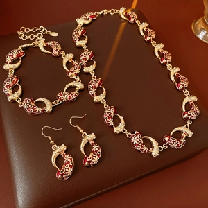 Detail of vintage red enamel and rhinestone jewelry set including necklace and bracelet