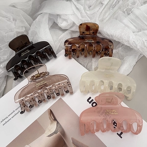 Set of five elegant translucent hair claw clips in various colors on a stylish magazine background