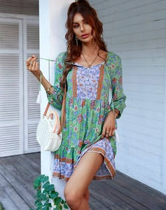 Dettaglio dell'abito corto da donna verde a fiori con scollo a V e design patchwork
