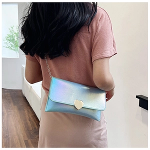 Detail of holographic envelope clutch featuring a golden heart lock and metal chain strap
