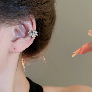 Silver heart ear cuff with cubic zirconia stones worn on the ear bone for women