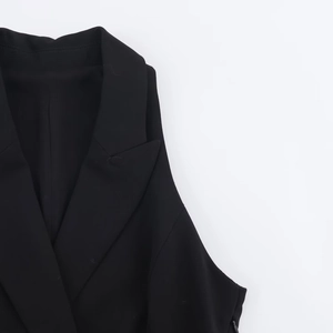 Détail du revers et des épaules structurées d'une robe blazer sans manches noire
