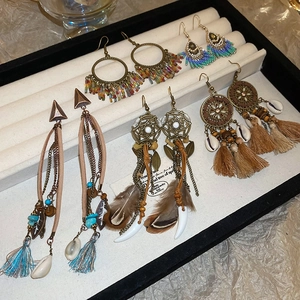 Detail view of Bohemian earring set featuring ethnic beads, tassels, and feathers