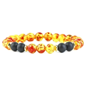 Detail of beaded bracelet featuring amber tiger eye, matte black beads and gold spacers