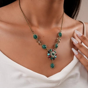 Close-up of vintage bronze necklace set with multi-colored crystals on a model