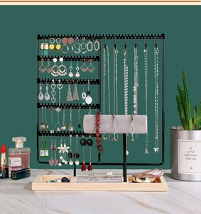 Detail view of black metal jewelry organizer with wooden tray and velvet bracelet bar