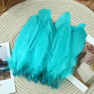 Macro shot of turquoise goose feathers on a woven mat for DIY craft decorations