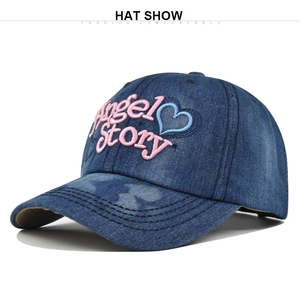 Dettaglio del ricamo Angel Story e del motivo a cuore sul cappellino da baseball in denim blu