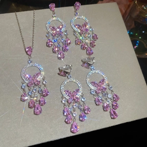 Macro view of zircon butterfly tassel necklace and earrings set with pink stones