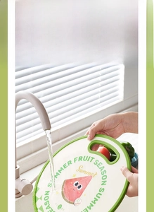 Close-up of easy-clean food-grade plastic cutting board being rinsed under running water