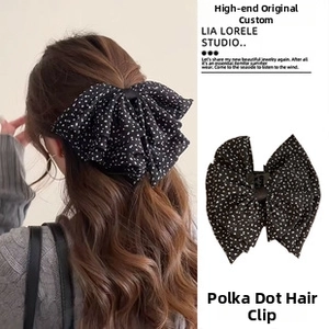 Close-up of black polka dot bow hair claw clip for women stylish hair accessory