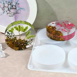 Close-up of a 4-cavity round silicone coaster mold with botanical resin art pieces