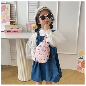 Pink canvas kids chest bag with unicorn and rainbow prints worn by a girl model