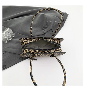 Detailed interior of leopard print baguette bag with grey lining and zipper closure