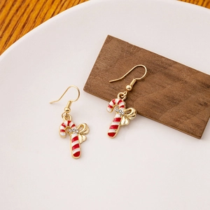 Detail of candy cane Christmas earrings with a red bow and sparkling crystal accents