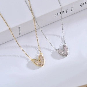 Collares de corazón de oro y plata con circonitas rosas sobre un libro abierto