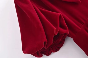 Gros plan détaillé du tissu en velours rouge foncé avec poignet élastique plissé