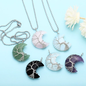 Detailed view of handmade tree of life wire-wrapped crescent moon crystal pendants
