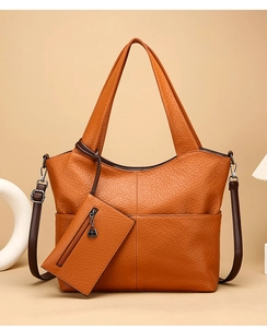 Macro detail of amber brown tote bag with leather texture and matching mini zipper pouch