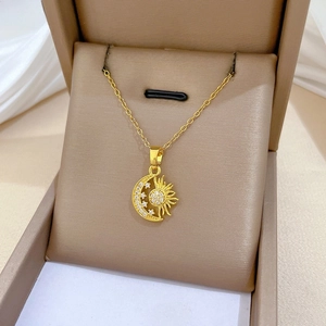 Detailed view of gold star and moon pendant necklace with zircon inlay in a gift box