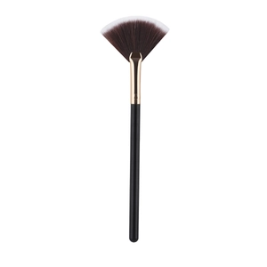 Macro detail of fan-shaped highlighter brush with golden ferrule and soft gradient bristles