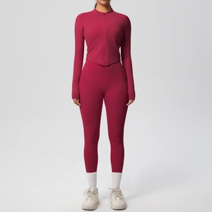 Détail d'un ensemble de sport rouge rose foncé avec veste zippée et legging de yoga taille haute