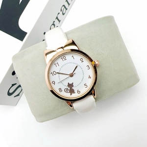 Close-up of rose gold cat ear watch with white dial and cute feline motif on strap