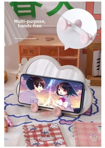 Detail of irregular cloud-shaped desk mirror with pink hooks supporting a smartphone
