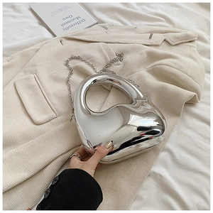 Close-up of stylish silver heart-shaped acrylic bag with elegant metallic chain strap