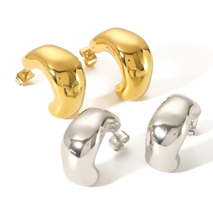 Irregular C-shaped earrings in polished gold and silver finish on a clean background