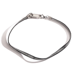 Close-up of a punk style zipper necklace with silver teeth and black fabric band
