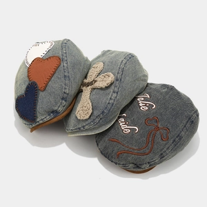 Detailed view of three vintage denim caps with heart patches, ropes, and embroidery details