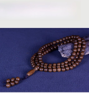 Macro shot of dark brown Liudaomu wood prayer beads with natural grain and silk tassels