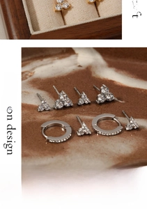 Detailed view of stainless steel clover stud earrings set with zircon in gold and silver