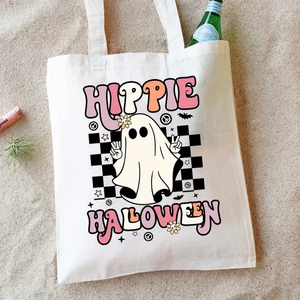 Detail of Hippie Halloween ghost print on cream canvas tote bag in a beach setting