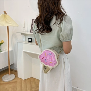 Pink glitter ice cream cone crossbody bag with gold chain strap worn by a model