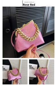 Close-up of rose red glossy leather bag with gold chain and metal frame detail