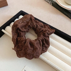 Close-up of brown double-layer lace scrunchie with intricate floral hollow embroidery