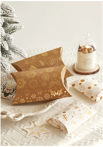 Close-up of pillow-shaped Christmas gift boxes with gold patterns and reindeer tags