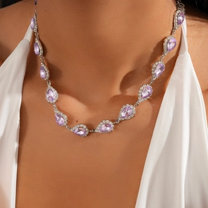 Close-up of purple teardrop crystal necklace with pavé diamond halo on model
