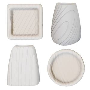 Macro detail of white ripple textured ceramic trays and spiral striped candle holders