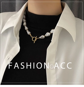 Close-up of irregular baroque pearl necklace with golden OT clasp on a model