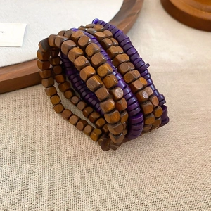 Detail view of vintage multi-layer wood beads bracelet with purple resin discs on linen