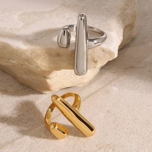 Minimalist 18k gold and silver geometric open rings on a natural stone base