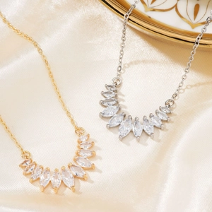 Elegant gold and silver marquise zircon drop necklaces set on a soft satin fabric