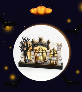 Macro shot of Halloween wooden light with graveyard gates and glowing LED light
