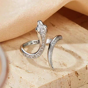 Detail of silver snake ring with green stone eyes and clear cubic zirconia pavé