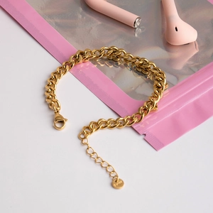 Detail of gold Cuban link bracelet with lobster clasp and adjustable extension chain