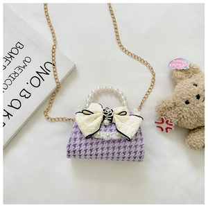 Detail of purple houndstooth girl's bag with pearl handle and large lace bow decoration